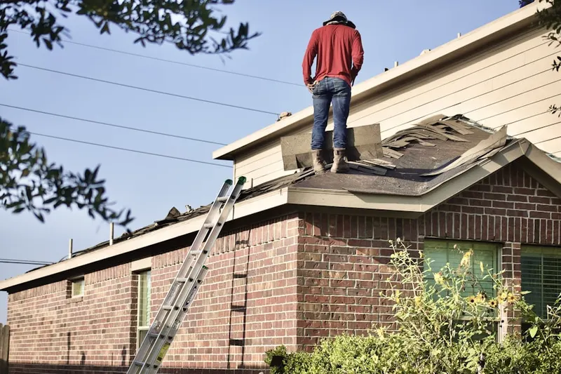 Professional roofer working on a residential roof in Leonard